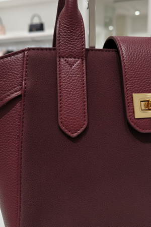 Dettaglio pelle martellata, camoscio e chiusura dorata della borsa Winter Bloom bordeaux RAELA