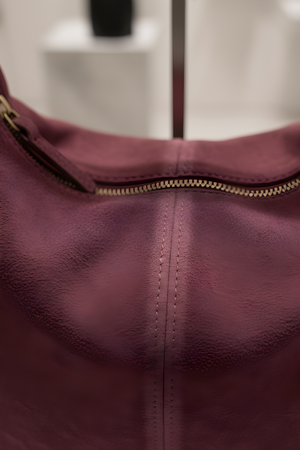 Primo piano camoscio bordeaux e zip della borsa con frange RAELA